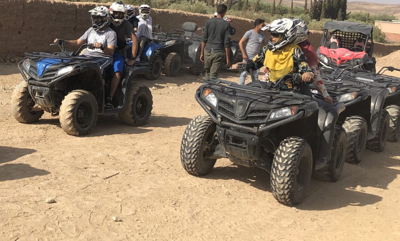 A group of people riding all-terrain vehicles on a dirt path.